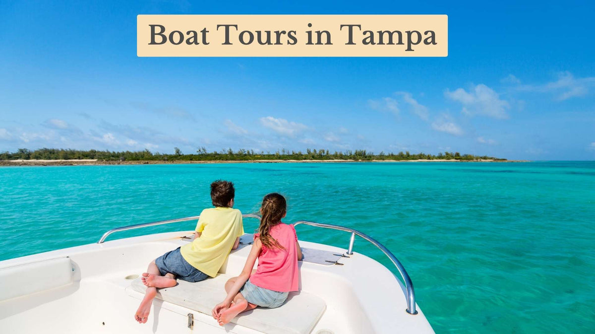 Boat Tours in Tampa: two barefoot children lie on a boat's bow looking out over turquoise water toward a green shoreline
