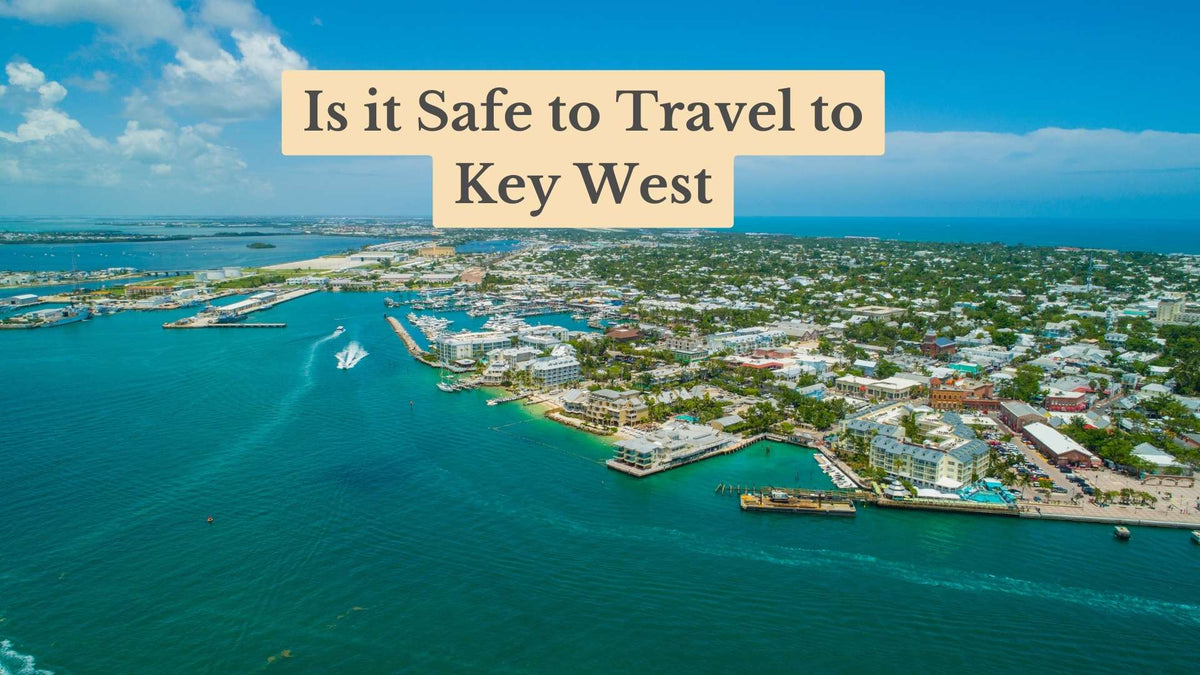 Aerial view of Key West's waterfront town and marina beside turquoise water, with the title "Is it Safe to Travel to Key West"