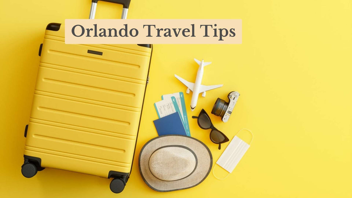 Title card "Orlando Travel Tips" over a yellow hard-shell suitcase, toy plane, tickets, passport, camera, sunglasses, sun hat and face mask.