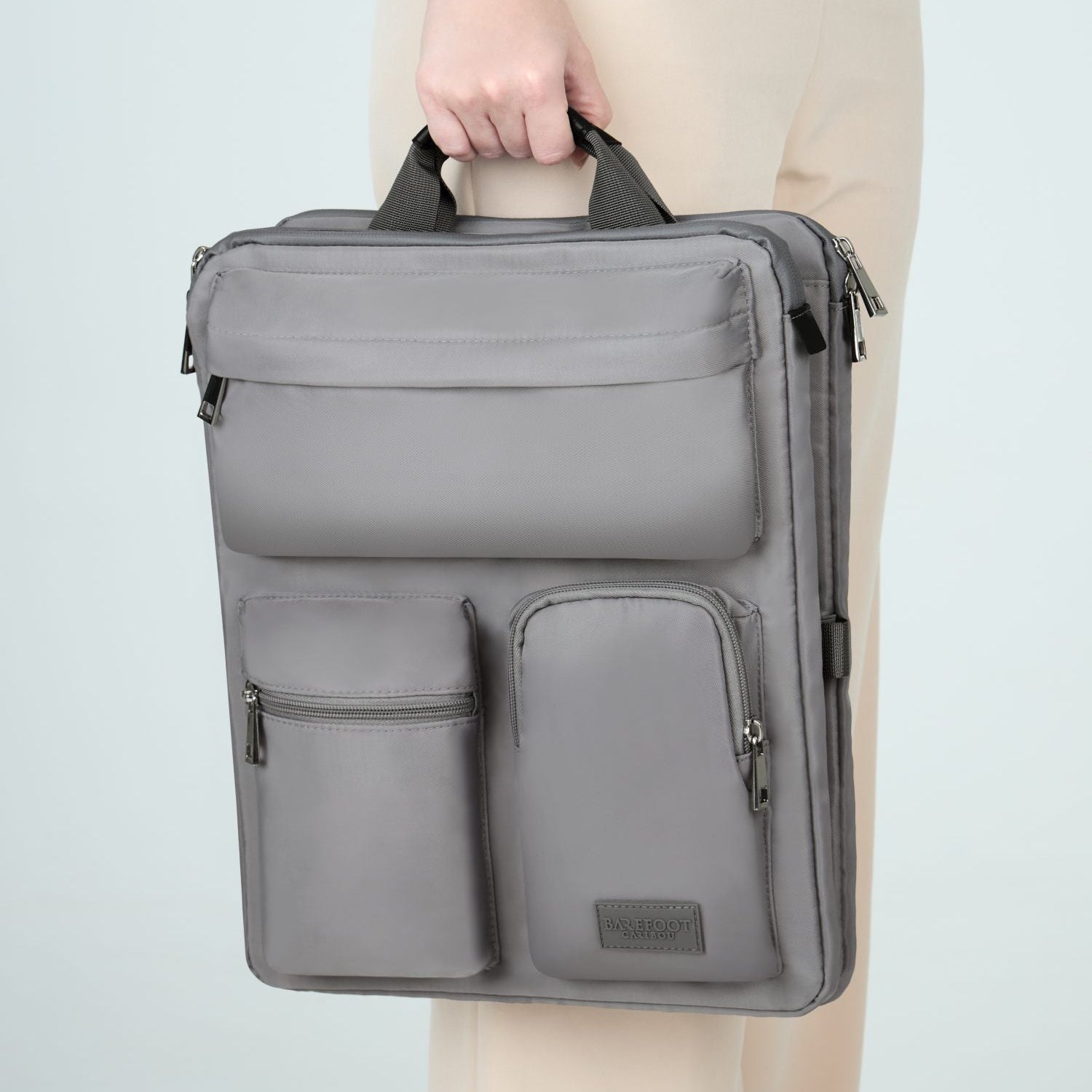 Person holding a gray over luggage organizer against a light background