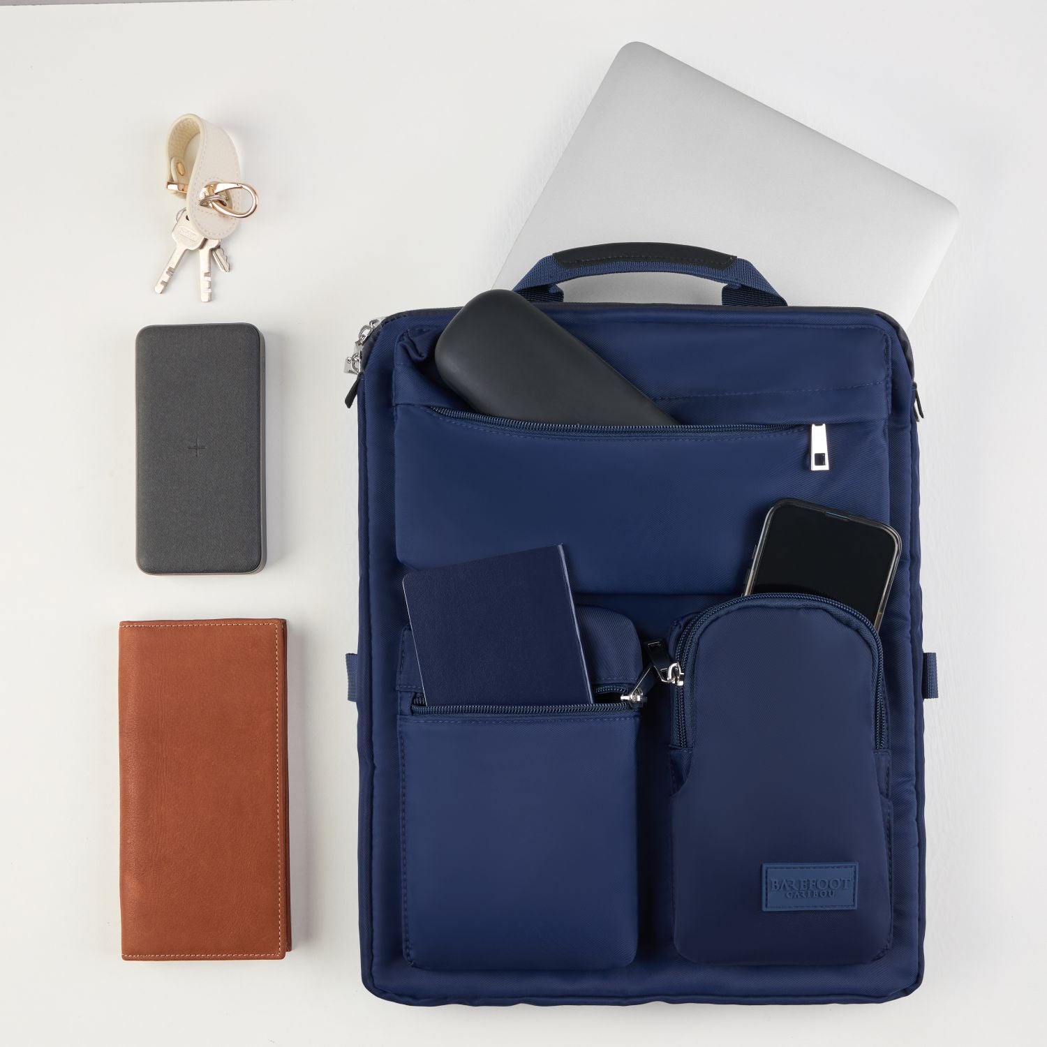 Navy blue over luggage organizer with compartments containing a phone, wallet, and other items on a white background